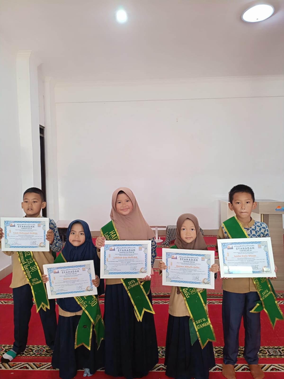 Santri tersenyum memegang sertifikat hafalan